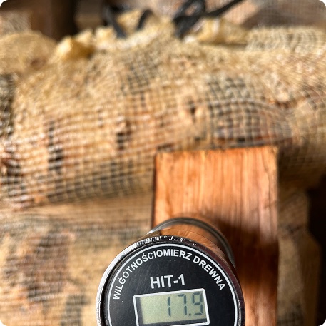 Moisture meter showing 17.9% on a kiln-dried split log